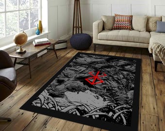 May include: A rectangular black and gray area rug with a detailed illustration. The rug features a grayscale design with a red emblem. The illustration depicts a face and other figures. The rug has a black border.