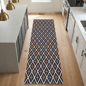 May include: A long, rectangular runner rug featuring a repeating diamond pattern in navy blue, cream, and orange. The design consists of interconnected cream-colored lines forming diamonds, with orange and gold-toned floral motifs centered within each shape.