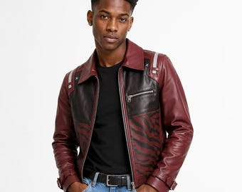 May include: A leather jacket featuring a colour-blocked design with deep burgundy sleeves and collar, and black chest panels. The lower front panels display a dark tiger stripe pattern. It includes silver-tone zips, shoulder epaulets, and adjustable cuffs.