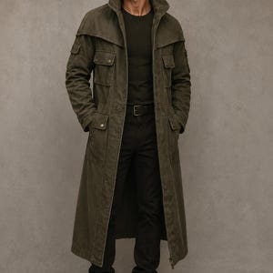 May include: An olive green long trench coat featuring a high collar, multiple flap pockets on the chest and hips, and a front zipper closure. The coat is worn over a dark green t-shirt, black trousers with a belt, and dark brown leather lace-up boots.