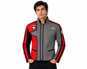 May include: A long-sleeve jacket featuring a colour-blocked design in grey, red, and black. The jacket includes a high collar, a front zip closure, and two patches on the chest: one with a dog silhouette and the word POLICE, and one reading SPD.