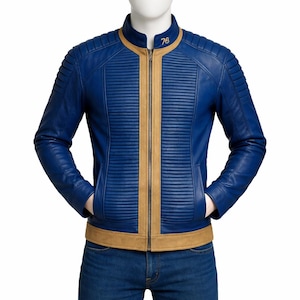 May include: A blue leather jacket with tan accents, featuring a ribbed design on the sleeves and chest. The jacket has a stand-up collar and a front zipper. The number "76" is embroidered on the collar. The jacket is displayed on a mannequin.