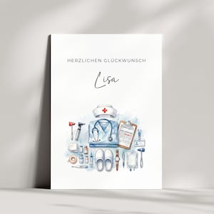 Può includere: Un biglietto d'auguri bianco con il testo HERZLICHEN GLÜCKWUNSCH e il nome Lisa in corsivo nero. Sotto, un'illustrazione ad acquerello mostra articoli medici tra cui una cuffia da infermiere, una divisa blu, uno stetoscopio e una cartellina.