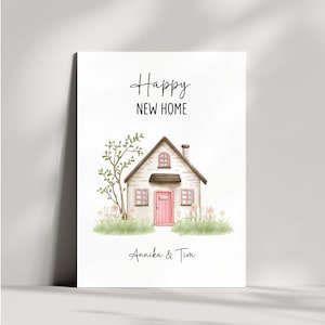 Può includere: Una stampa ad acquerello raffigurante una casa affascinante con una porta e finestre rosa, un piccolo albero e la scritta "Happy New Home". I nomi "Annika & Tim" sono scritti sotto la casa, rendendolo un regalo personalizzato.