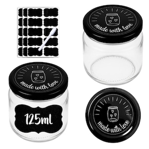 Op de afbeelding: Transparante glazen potten met zwarte deksels, elk met een potillustratie en de woorden "made with love". De set bevat blanco zwarte etiketten en een witte stift. Eén pot heeft een etiket met de tekst "125ml".