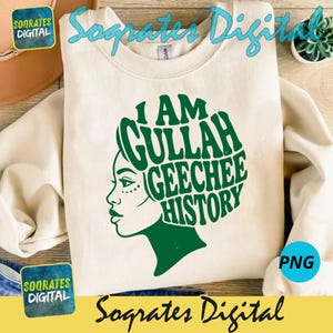 May include: A cream-coloured sweatshirt with a green graphic. The graphic shows a woman's profile and the words "I AM GULLAH GEECHEE HISTORY" in a stylized font. The sweatshirt has a crew neck and long sleeves.