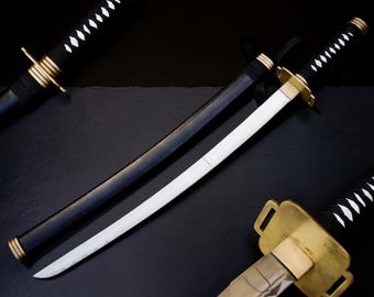 May include: A set of three swords featuring black scabbards and handles with white diamond-shaped accents. Each sword has a gold-colored metal guard and a silver-toned blade. The handles are wrapped in black cord, and the scabbards are smooth black.