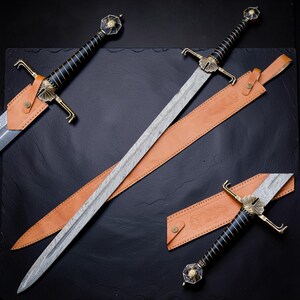 Op de afbeelding: Twee zwaarden met Damascus stalen bladen en zwart omwikkelde handvatten. De gevesten hebben versierde messing pareerstangen en knoppen met cirkelvormige accenten. Elk zwaard bevat een lichtbruine lederen schede met een riem en knoop.