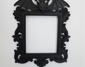 May include: Black ornate picture frame featuring a bat motif. The frame has a square aperture and decorative scrollwork. Text on the image reads "STL + 3MF FILE" and "DIGITAL FILE FOR 3D PRINTING".