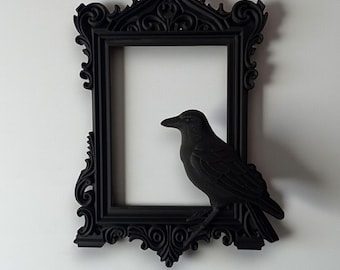 May include: A black decorative frame with ornate detailing and a perched raven. The frame has a rectangular opening and is embellished with scrollwork. Text at the top reads "STL + 3MF FILE" and at the bottom "DIGITAL FILE FOR 3D PRINTING".