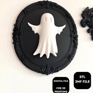 Puede incluir: Una figura de fantasma blanco con los brazos extendidos está centrada en un fondo ovalado negro dentro de un marco negro decorativo. La imagen incluye el texto "DIGITAL FILE FOR 3D PRINTING" y "STL 3MF FILE".