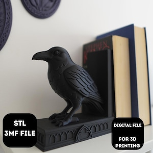 Könnte beinhalten: Ein schwarzer Raben-Buchstütze mit detaillierten Merkmalen, neben zwei Büchern platziert. Das Bild zeigt auch zwei dunkelblaue Wanddekorationen und den Text "STL 3MF FILE" und "DIGITAL FILE FOR 3D PRINTING". Die Buchstütze steht auf einem dekorativen Sockel.