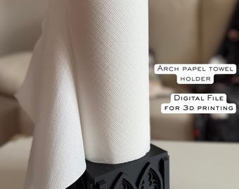 May include: Black paper towel holder with an arched design, holding a roll of white paper towels. The holder has a square base and a black top. Text on the image reads "ARCH PAPEL TOWEL HOLDER" and "DIGITAL FILE FOR 3D PRINTING."