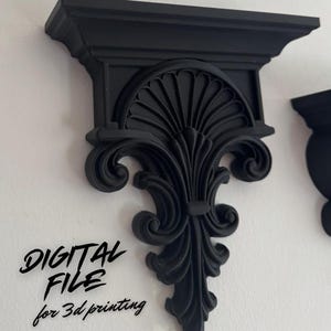 May include: Black decorative wall shelf with intricate scrollwork and a flat top. The shelf is mounted on a white wall. The text "DIGITAL FILE for 3d printing" is written on the wall.