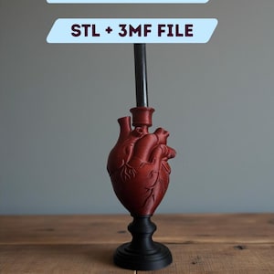 Op de afbeelding: Een 3D-geprinte anatomische hartkaarsenhouder in rood, op een zwarte basis. Het ontwerp bevat een centrale steel voor een kaars. Tekst op de afbeelding luidt "DIGITAL FILE FOR 3D PRINTING" en "STL + 3MF FILE".