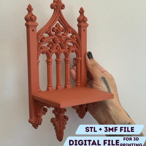 Op de afbeelding: Een terracotta-kleurig, sierlijk plankje met een gotisch architectonisch ontwerp. Het plankje heeft ingewikkelde details, waaronder bogen, kolommen en decoratieve versieringen. De tekst "STL + 3MF FILE" en "DIGITAL FILE FOR 3D PRINTING" zijn zichtbaar.