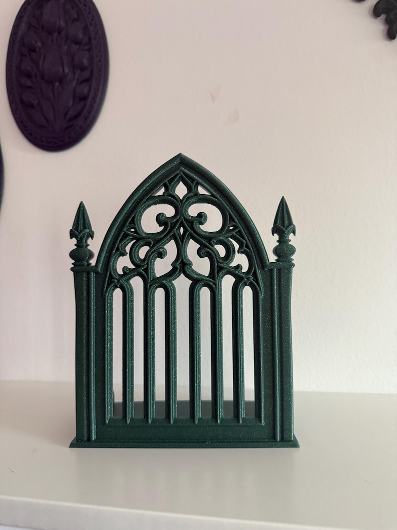 Peut inclure: Une fen&ecirc;tre ou porte d&eacute;corative de style gothique vert fonc&eacute;. Le design complexe pr&eacute;sente des arcs bris&eacute;s, des barres verticales et des volutes orn&eacute;es. Il s'agit probablement d'un &eacute;l&eacute;ment d&eacute;coratif pour la d&eacute;coration int&eacute;rieure ou les projets d'artisanat.