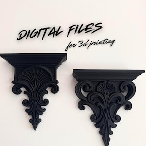 May include: Two black decorative wall shelves with ornate, scrollwork designs. The shelves are mounted on a white wall. Text above the shelves reads "DIGITAL FILES for 3d printing."