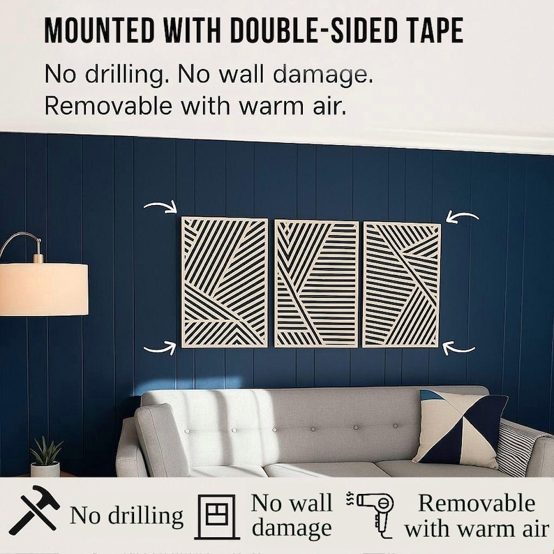 May include: Three geometric wall art panels with black and white linear designs are mounted on a dark blue wall. The text above reads "MOUNTED WITH DOUBLE-SIDED TAPE" and below, "No drilling. No wall damage. Removable with warm air."