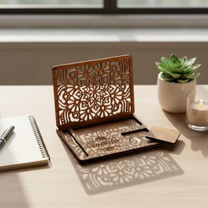 May include: A brown wooden business card holder with a decorative openwork floral pattern. The holder has a slot for cards and a small wooden card. The name "Sophia" is engraved on the front.