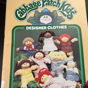 May include: A Cabbage Patch Kids Designer Clothes sewing pattern booklet, number 7686, featuring Xavier Roberts Presents branding. The cover displays seven dolls in various outfits, with text stating Patterns Ready-to-Cut and Make 25 Outfits.