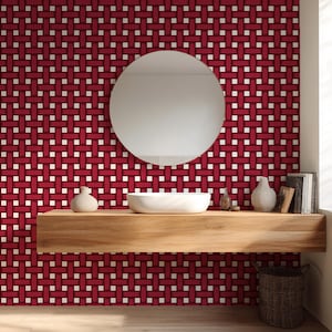 May include: A modern bathroom scene featuring a red and white woven pattern wallpaper. A round mirror hangs above a wooden floating shelf with a white sink, vases, and books. A woven basket sits below.