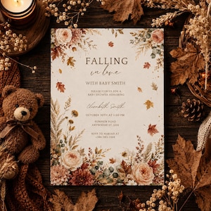 May include: A rectangular baby shower invitation card featuring the text FALLING in love WITH BABY SMITH, ELIZABETH SMITH, OCTOBER 30TH AT 2:00 PM, PUMPKIN ROAD, ANYWHERE ST. 1234, and RSVP TO MARIAH AT +384-383-2344, decorated with watercolor autumn flowers.