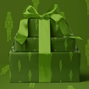 Op de afbeelding: Drie gestapelde, verpakte cadeaus in groentinten, vastgebonden met een bijpassend groen satijnen lint en strik. Het cadeaupapier heeft een herhalend patroon van silhouetten van notenkrakersoldaten. De achtergrond is effen groen.