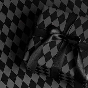 Peut inclure: Un cadeau emball&eacute; avec un motif arlequin noir et gris, nou&eacute; avec un ruban et un n&oelig;ud en satin noir. Le cadeau repose sur une surface &agrave; motif arlequin assorti.