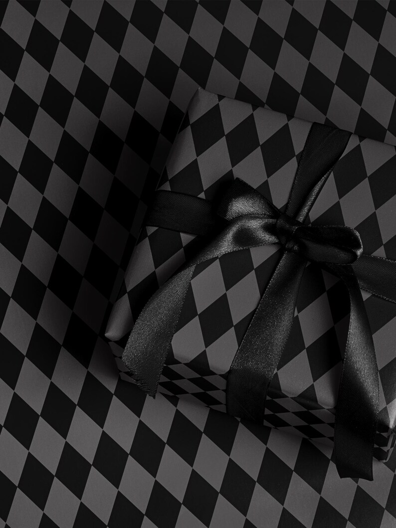 Peut inclure: Un cadeau emball&eacute; avec un motif arlequin noir et gris, nou&eacute; avec un ruban et un n&oelig;ud en satin noir. Le cadeau repose sur une surface &agrave; motif arlequin assorti.