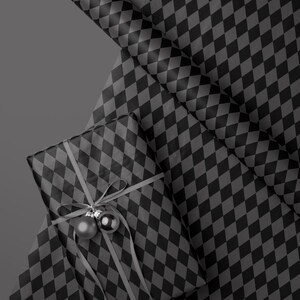 Peut inclure: Un cadeau emball&eacute; avec un ruban gris et deux boules argent&eacute;es, pos&eacute; sur une feuille de papier cadeau. Le papier cadeau et le cadeau sont recouverts d'un motif de losanges noirs et gris. Un rouleau de papier cadeau assorti est &eacute;galement visible.