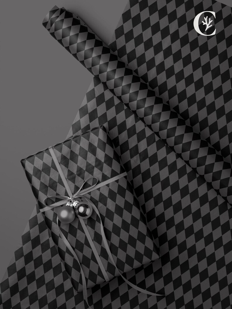 Peut inclure: Un cadeau emball&eacute; avec un ruban gris et deux boules argent&eacute;es, pos&eacute; sur une feuille de papier cadeau. Le papier cadeau et le cadeau sont recouverts d'un motif de losanges noirs et gris. Un rouleau de papier cadeau assorti est &eacute;galement visible.