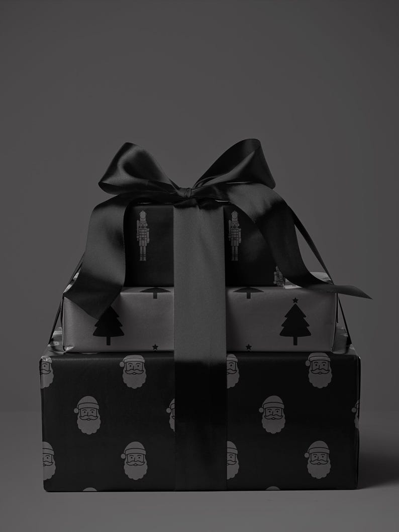 May include: Three wrapped gifts stacked on top of each other, tied with a large black satin bow. The wrapping paper features repeating patterns of a Santa face, a Christmas tree, and a nutcracker soldier. The gifts are in shades of gray and black.