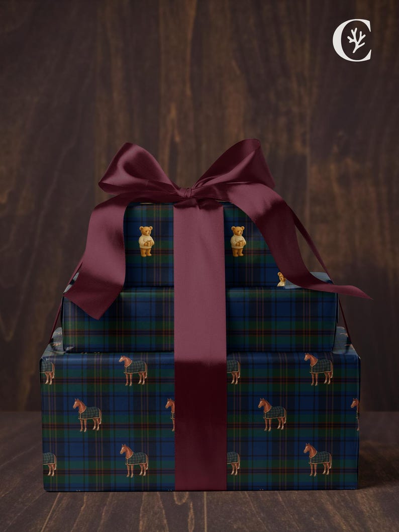 May include: Stacked gift boxes wrapped in blue, green, and black plaid paper with horse and teddy bear designs. A large burgundy bow and ribbon adorn the top. The boxes are on a wooden surface.