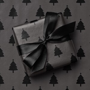 May include: A wrapped gift with black wrapping paper featuring a repeating pattern of Christmas trees. The gift is tied with a black satin ribbon, forming a bow on top. The background is the same wrapping paper.
