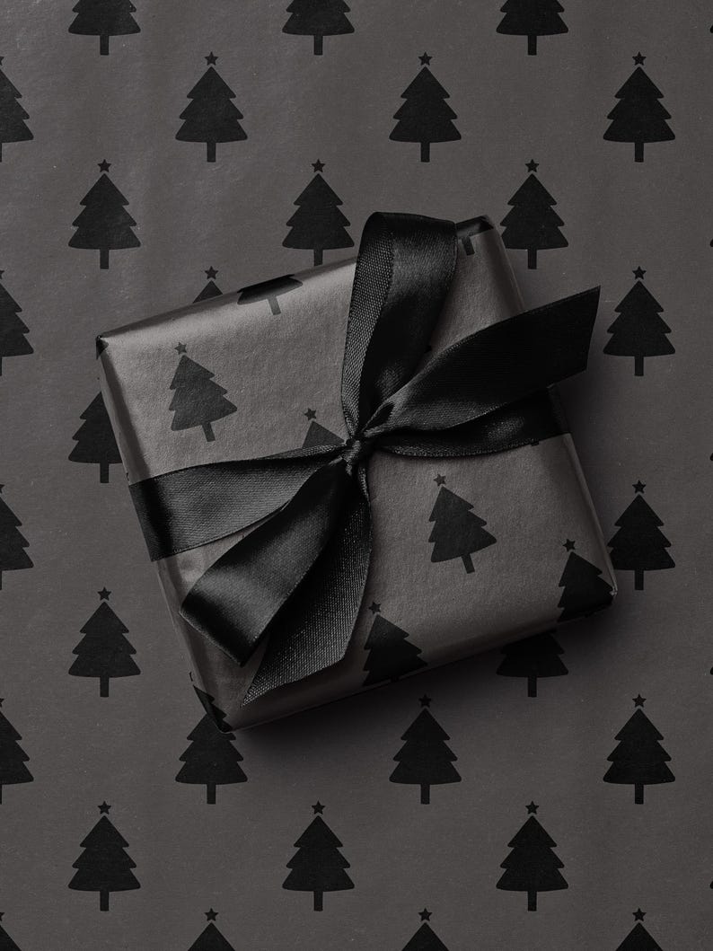 May include: A wrapped gift with black wrapping paper featuring a repeating pattern of Christmas trees. The gift is tied with a black satin ribbon, forming a bow on top. The background is the same wrapping paper.