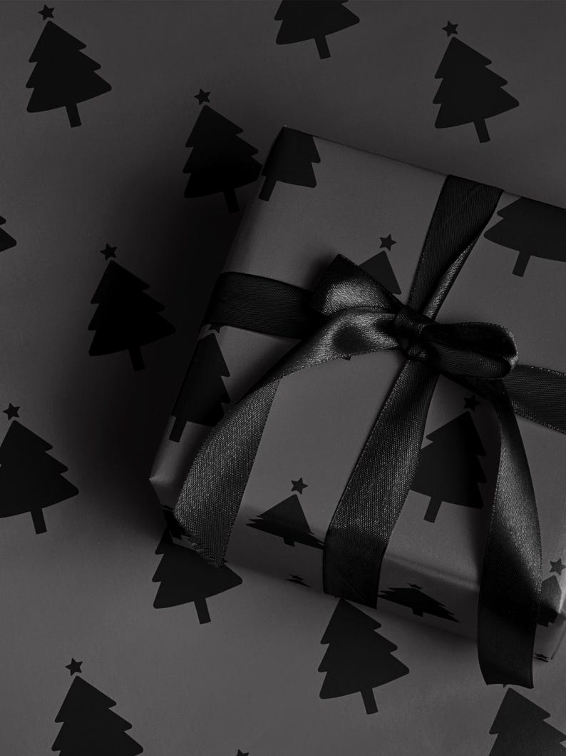 May include: A wrapped gift with black wrapping paper featuring a repeating pattern of Christmas trees. The gift is tied with a black satin ribbon and bow. The background is the same wrapping paper.