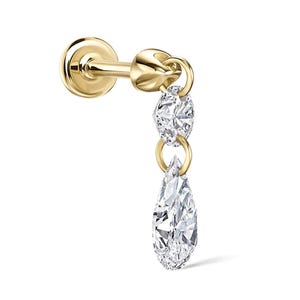 May include: A gold stud earring with a dangling design. The earring has a round stud, a small round accent, and a teardrop-shaped clear gemstone. The earring is set against a white background.
