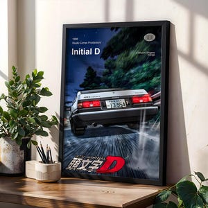 Könnte beinhalten: Gerahmtes Initial D-Poster mit einem weißen und schwarzen Auto, das nachts auf einer Straße fährt. Das Poster enthält den Text "Initial D" auf Englisch und Japanisch, mit Produktionsdetails und einem Kennzeichen.
