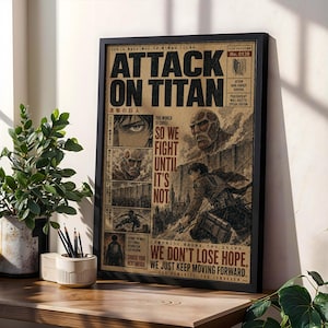 Könnte beinhalten: Ein gerahmtes Poster mit Attack on Titan-Grafiken im Stil einer alten Zeitung. Der Druck enthält den Text "The world is cruel. So we fight until it's not. We don't lose hope. We just keep moving forward." sowie verschiedene Manga-Panels.
