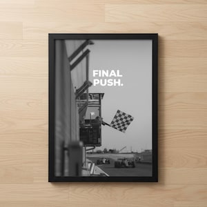 Könnte beinhalten: Schwarz-Weiß-Druck in einem Rahmen, der eine Rennstrecke zeigt. Das Bild zeigt Rennwagen, eine Zielflagge und den Text "FINAL PUSH". Der Druck wird auf einer hellen Holzoberfläche präsentiert.