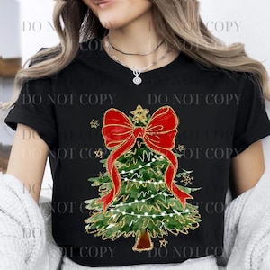 May include: Black t-shirt featuring a Christmas tree design. The tree is green with gold accents, a red bow, and string lights. The words "DO NOT COPY" are printed on the shirt.