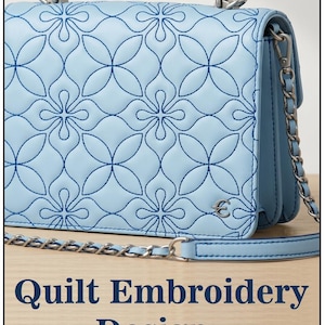Könnte beinhalten: Eine hellblaue Handtasche mit einer dunkelblauen Steppstickerei in einem sich wiederholenden Blumenmuster. Die Tasche verfügt über einen Tragegriff, einen silberfarbenen Metallkettenschulterriemen und ein kleines silbernes Logo. Text: Quilt Embroidery Design.