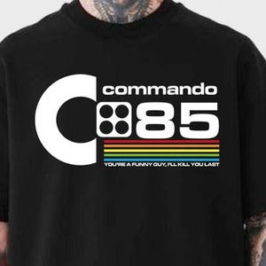 May include: Black t-shirt with a white graphic that reads "commando 85" with a large white "C" and a rainbow stripe. The text "YOU'RE A FUNNY GUY, I'LL KILL YOU LAST" is below the stripe.