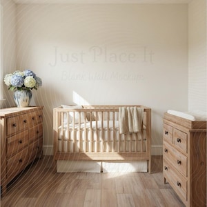 Puede incluir: Una escena de guardería con una cuna de madera clara con una manta y ropa de cama de tonos neutros. También hay una cómoda y un cambiador a juego. Un jarrón con flores azules y blancas descansa sobre una cómoda de madera. El ambiente es cálido.