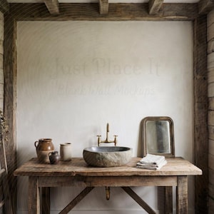 Puede incluir: Escena de baño rústico con una mesa de madera, un lavabo de piedra y un grifo de latón. Un espejo pequeño, toallas y cerámica están dispuestos sobre la mesa. Una escalera de madera con hierbas secas se apoya contra una pared de madera.