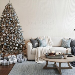 Könnte beinhalten: Ein geschmückter Weihnachtsbaum mit blauen und silbernen Ornamenten und Lichtern steht neben einem weißen Sofa mit dekorativen Kissen und einer Decke. Ein runder Couchtisch aus Holz beherbergt Kerzen und ein Tablett. Geschenkverpackungen liegen unter dem Baum.