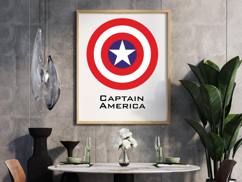 K&ouml;nnte beinhalten: Gerahmter Druck mit dem Schild von Captain America. Das Schild ist ein roter Kreis mit einem wei&szlig;en Stern in einem blauen Kreis in der Mitte. Der Text "CAPTAIN AMERICA" ist darunter in Schwarz gedruckt. Der Druck ist in einem Holzrahmen.