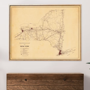 May include: Vintage transportation map of New York State with a beige background and brown lines showing roads and railroads. The map is framed in a light wood frame.