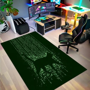 May include: A dark green rectangular rug with a matrix-style design. The rug features a silhouette of a wolf and a pattern of green code. The rug is placed in a gaming room with a computer setup and a black gaming chair.